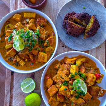 Bowl of creamy chicken and tofu tikka masala served with crispy onion bhajis and brown rice