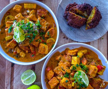 Bowl of creamy chicken and tofu tikka masala served with crispy onion bhajis and brown rice