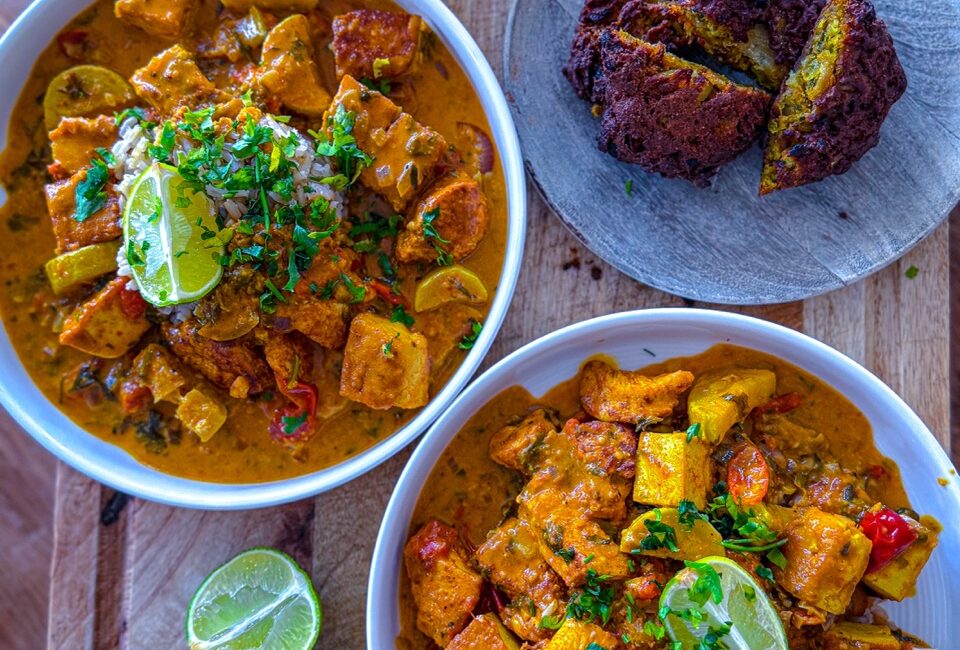 Bowl of creamy chicken and tofu tikka masala served with crispy onion bhajis and brown rice
