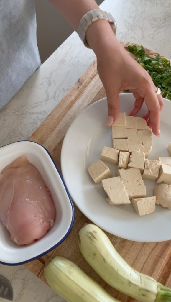Ingredients for creamy chicken tofu tikka masala including chicken breast, tofu, tikka paste, coconut cream and spices