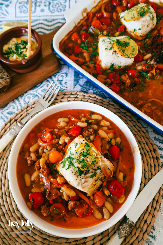 Close-up of baked cod with chorizo, beans and a paprika-lemon drizzle.