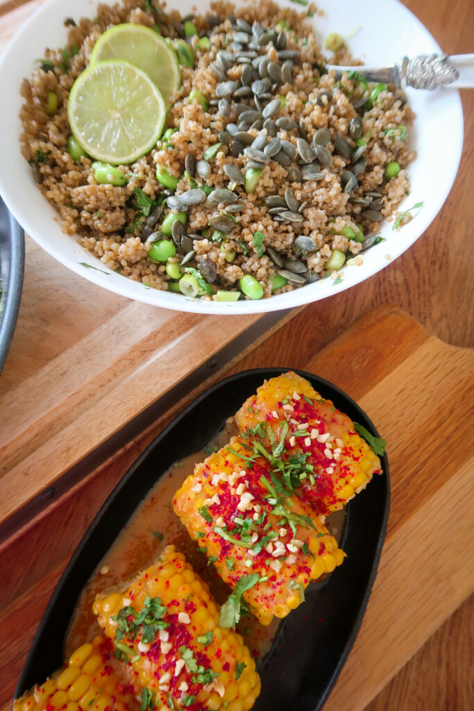 Glazed salmon fillet atop garlic-ginger quinoa pilaf with miso-glazed corn and fresh herbs.
