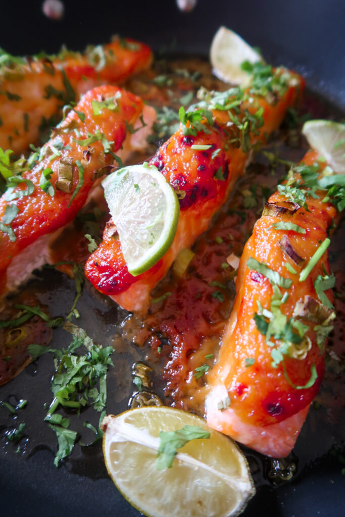 Glazed salmon fillet atop garlic-ginger quinoa pilaf with miso-glazed corn and fresh herbs.