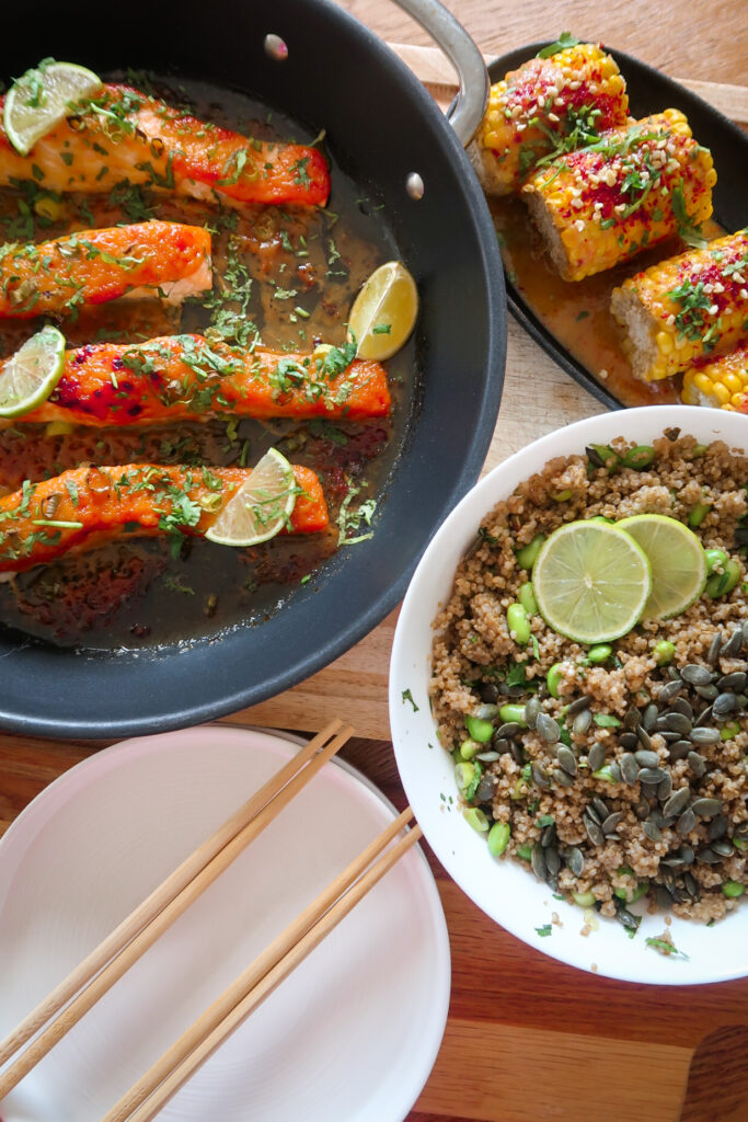 Glazed salmon fillet atop garlic-ginger quinoa pilaf with miso-glazed corn and fresh herbs.