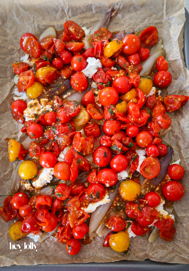 Caramelised shallots and cherry tomatoes in a pan for tart filling