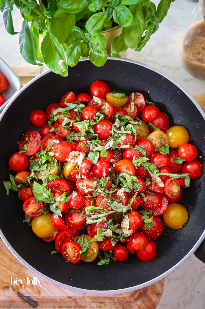 Caramelised shallots and cherry tomatoes in a pan for tart filling