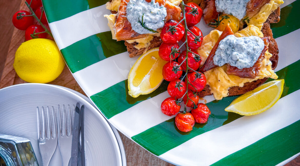 Scandi-style breakfast with eggs, mackerel, tomatoes, and crème fraîche on sourdough.