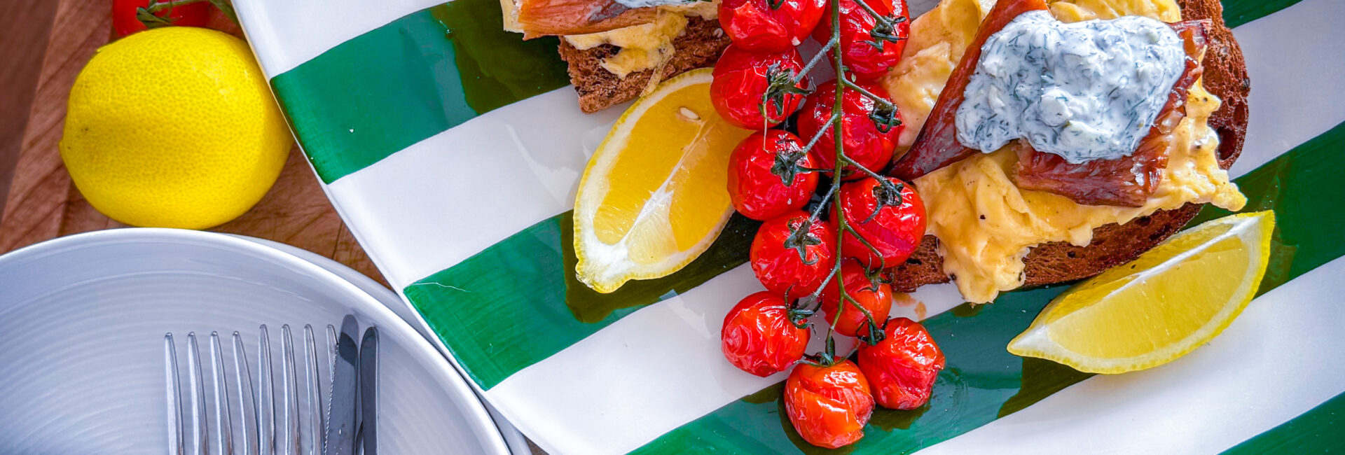 Scandi-style breakfast with eggs, mackerel, tomatoes, and crème fraîche on sourdough.