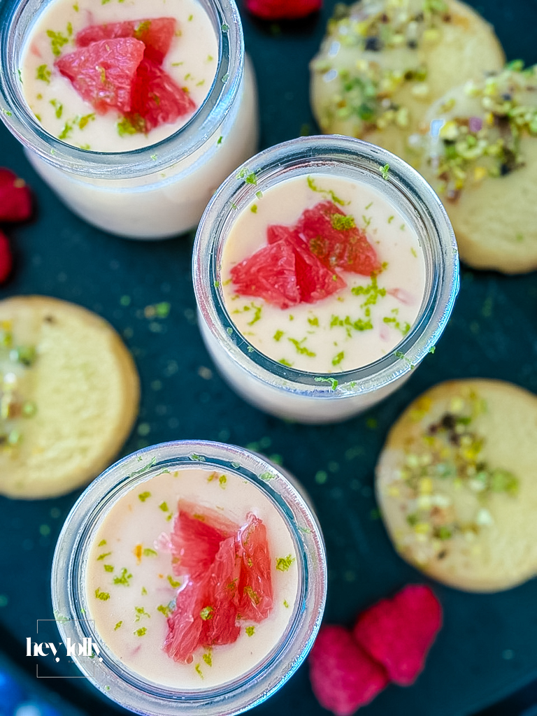Silky grapefruit posset in glass ramekin with pistachio shortbread on the side