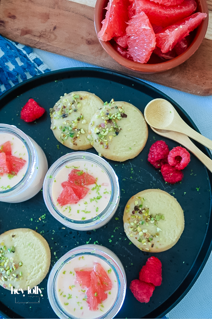 Silky grapefruit posset in glass ramekin with pistachio shortbread on the side