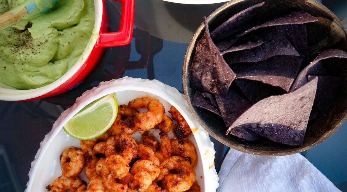 Seared prawns with avocado cream and summer salsa on table to share