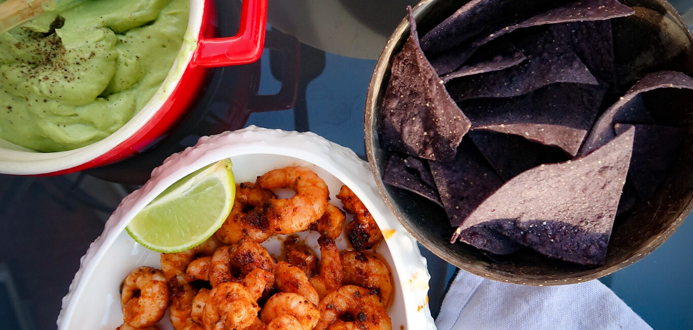 Seared prawns with avocado cream and summer salsa on table to share