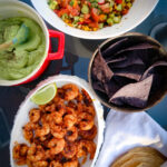 Seared prawns with avocado cream and summer salsa on table to share