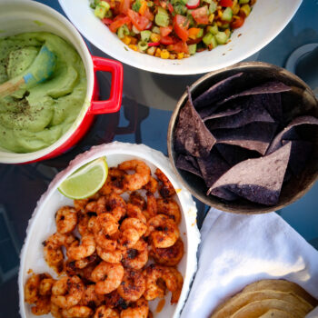 Seared prawns with avocado cream and summer salsa on table to share