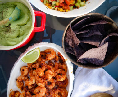 Seared prawns with avocado cream and summer salsa on table to share