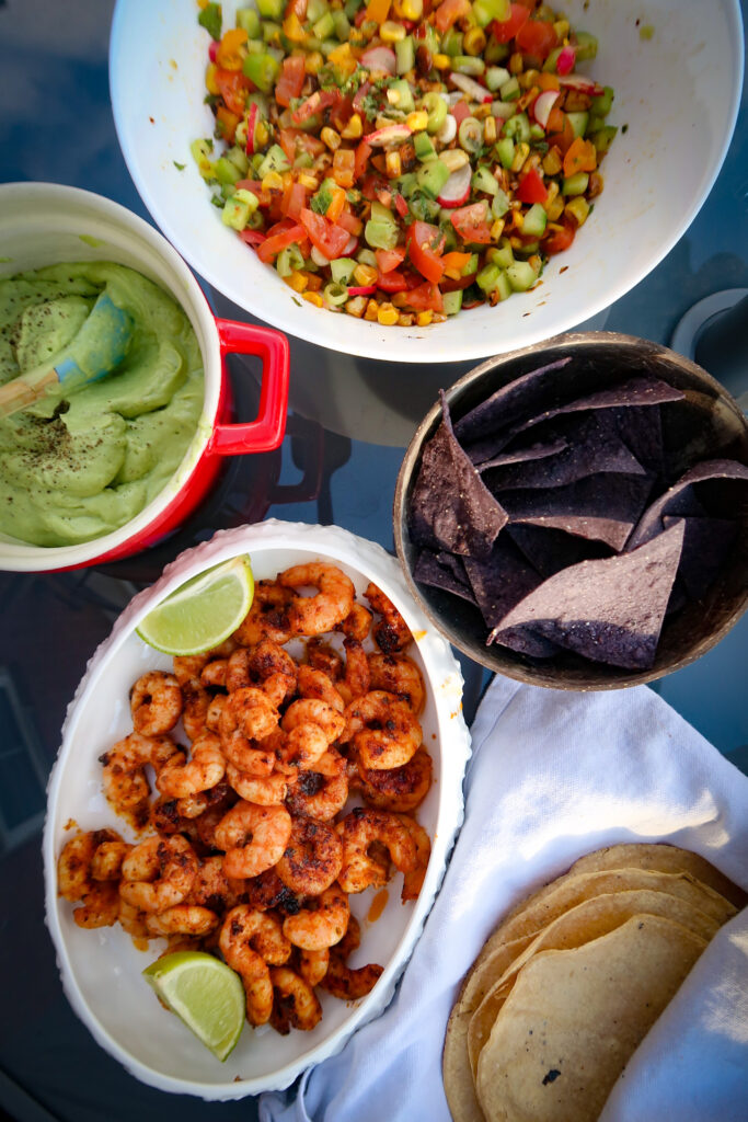 Ingredients for seared prawns with avocado cream including prawns, avocados, tomatoes and fresh herbs