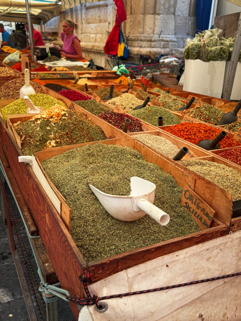Fresh produce stalls at Ortigia’s daily open market with spices