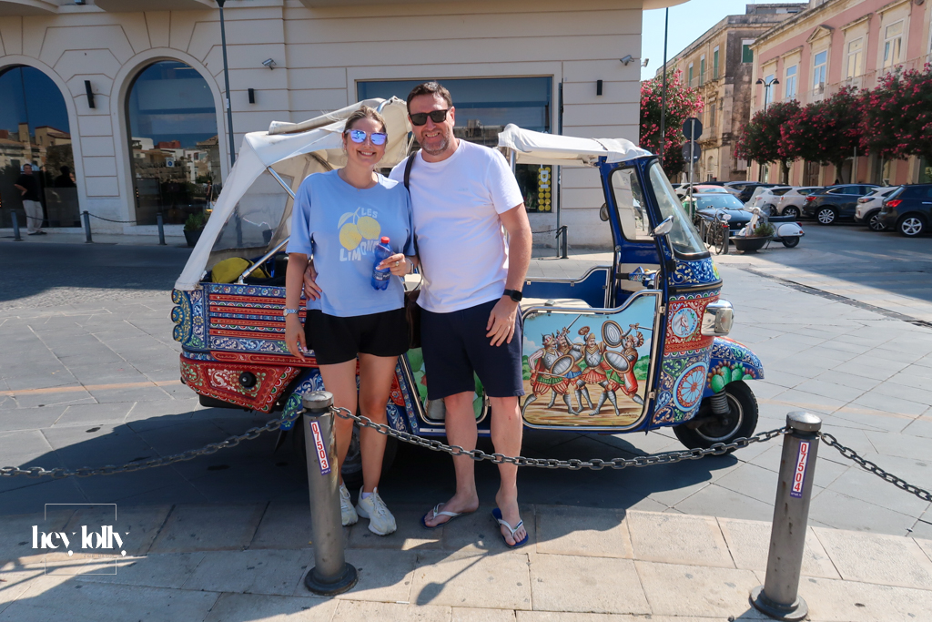 Colourful tuk tuk driving through narrow streets in Ortigia Sicily