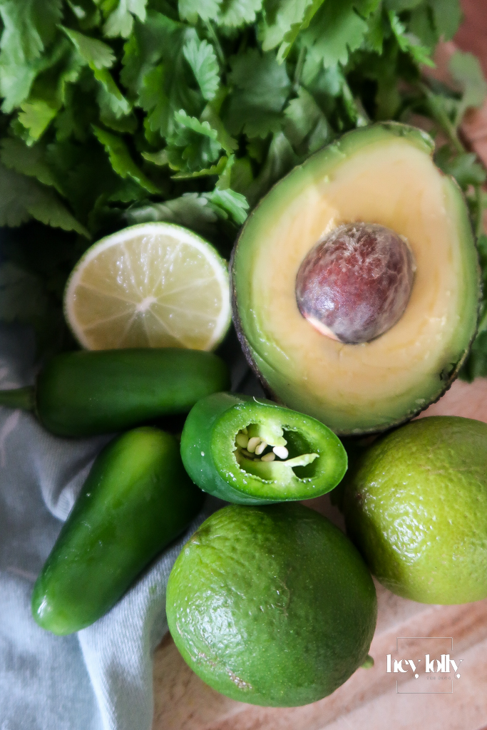 Colourful burrito bowl ingredients including chicken, rice, avocado, beans, sweetcorn, cheese, and lime.