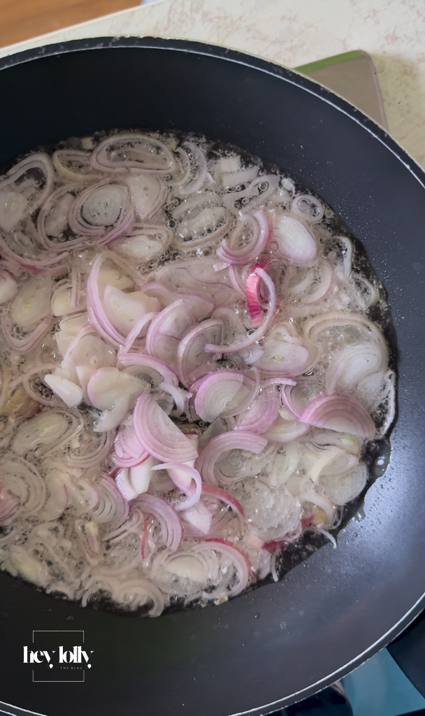 Thinly sliced shallots frying until golden and crisp in hot oil