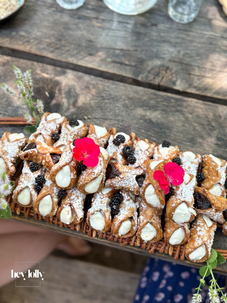 Traditional Sicilian cannoli dusted with sugar and decorated with flowers, served at a cooking class in Syracuse Sicily.