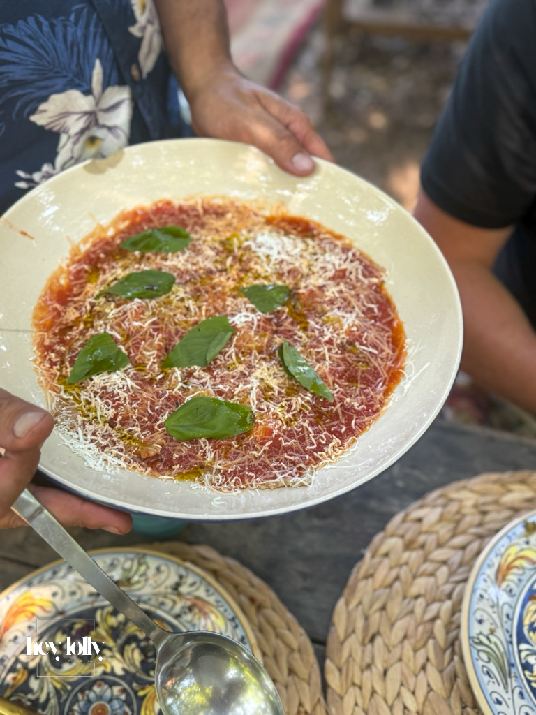 Large bowl of Sicilian pasta with tomato sauce and basil, topped with cheese, served at Slow Life Family Farm.