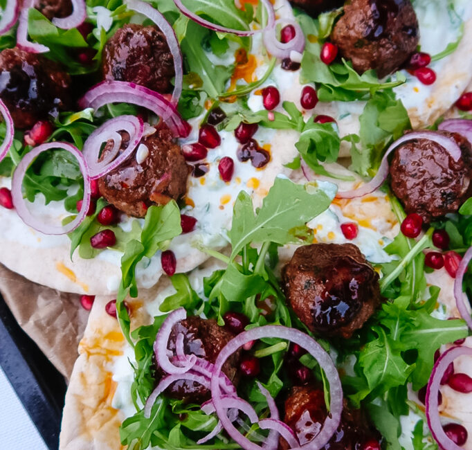 Harissa lamb meatballs glazed with pomegranate molasses on flatbread