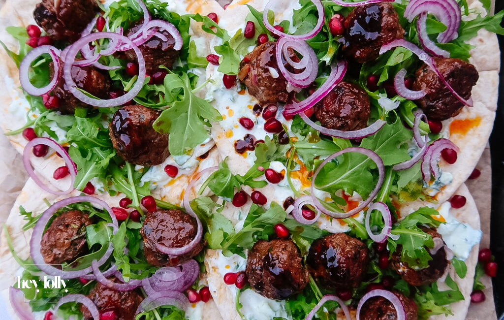 Harissa lamb meatballs glazed with pomegranate molasses on flatbread