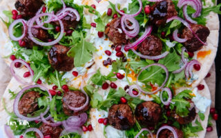 Harissa lamb meatballs glazed with pomegranate molasses on flatbread