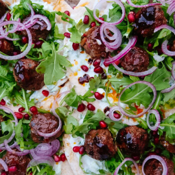 Harissa lamb meatballs glazed with pomegranate molasses on flatbread