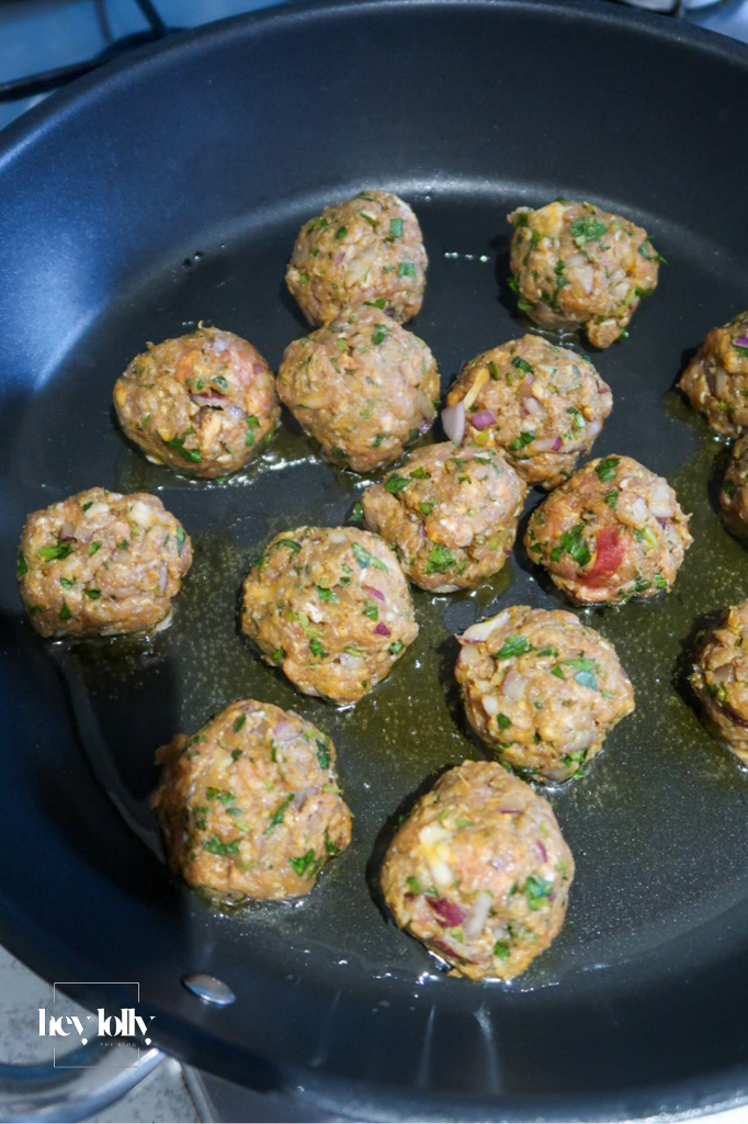 rolled harissa lamb meatballs cooking in the frying pan