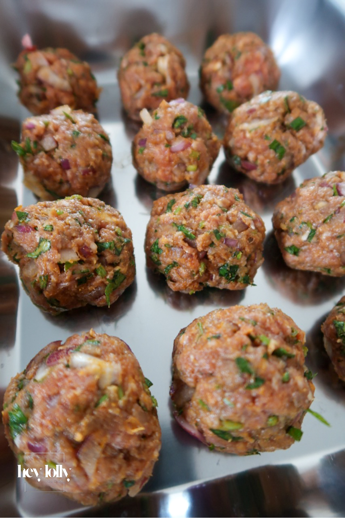 Raw lamb mince rolled into meatballs with harissa paste, onion, garlic, cumin, parsley, and egg — base ingredients for Harissa Lamb Meatballs with Pomegranate Molasses