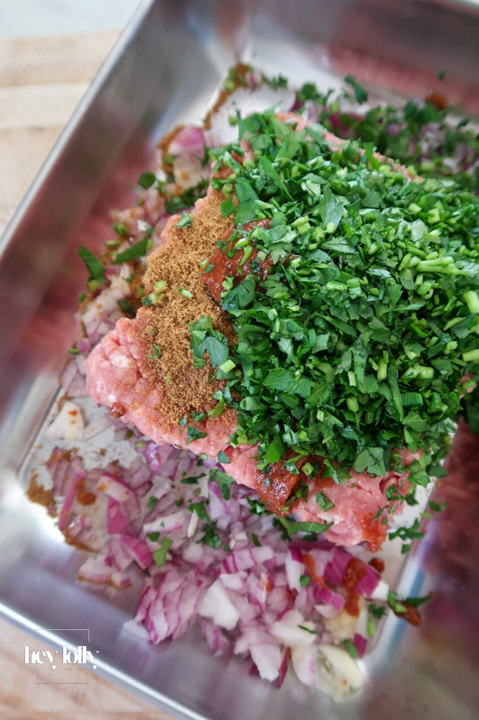 Raw lamb mince with harissa paste, onion, garlic, cumin, parsley, and egg — base ingredients for Harissa Lamb Meatballs with Pomegranate Molasses