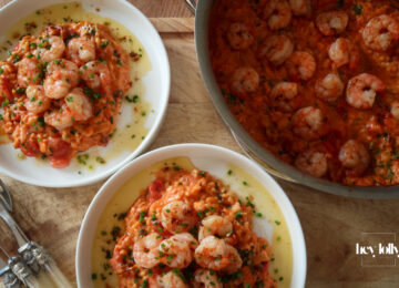 Creamy king prawn tomato risotto served with garlic lemon butter and chives