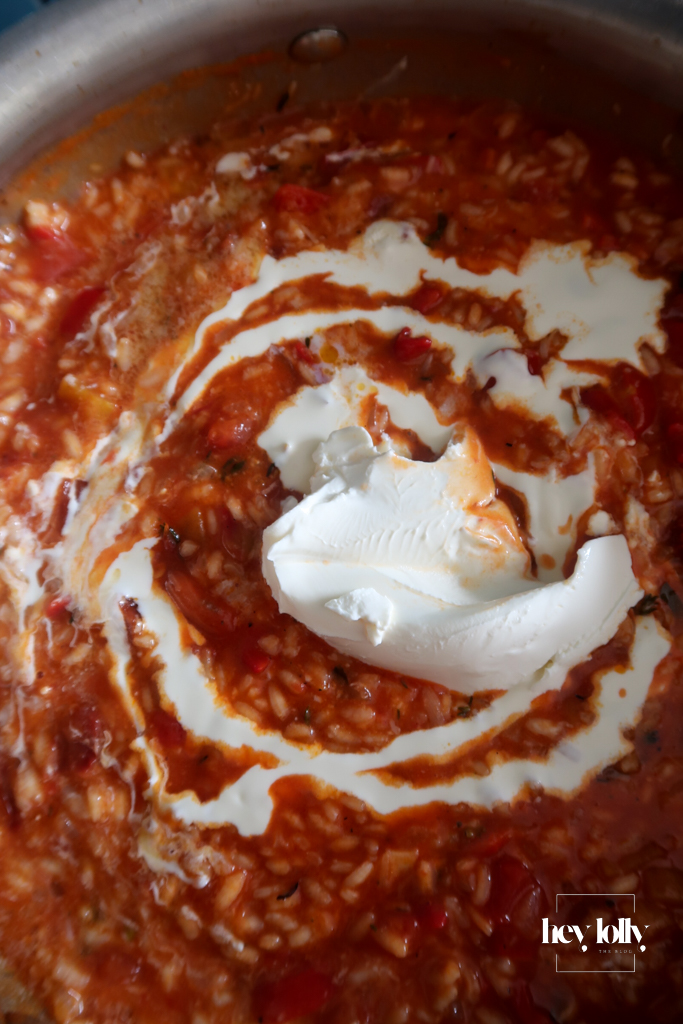 Close-up of creamy risotto bubbling in the pan with tomatoes and mascarpone and double cream