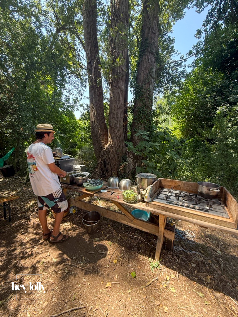 Group preparing fresh vegetables at rustic outdoor tables at Slow Life Family Farm, Siracusa.