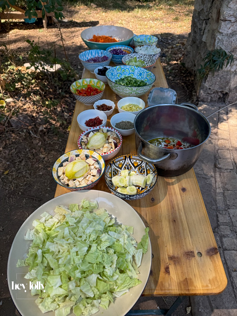 Participants chopping herbs and sharing tasks in the open-air kitchen in Syracuse Sicily.