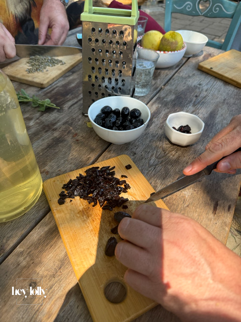 Participants chopping herbs and sharing tasks in the open-air kitchen in Syracuse Sicily.