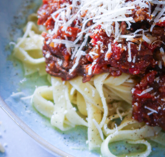 plated rich beef ragu with tagliatelle and freshly shaved parmesan