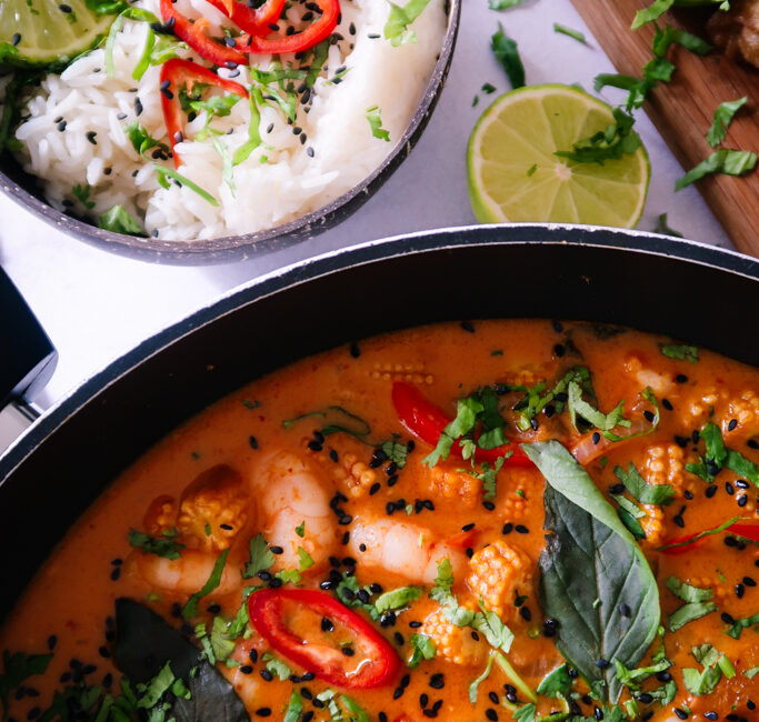 Close-up of Thai Red King Prawn curry showing prawns in creamy coconut-red sauce.