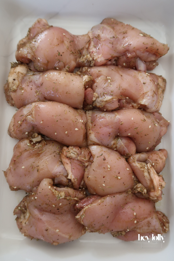 Overhead shot of chicken thighs with Mediterranean spices and salsa ingredients for Za’atar Chicken Thighs recipe