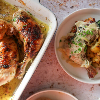overhead shot of plated garlic roast butter chicken with lemon cavolo nero