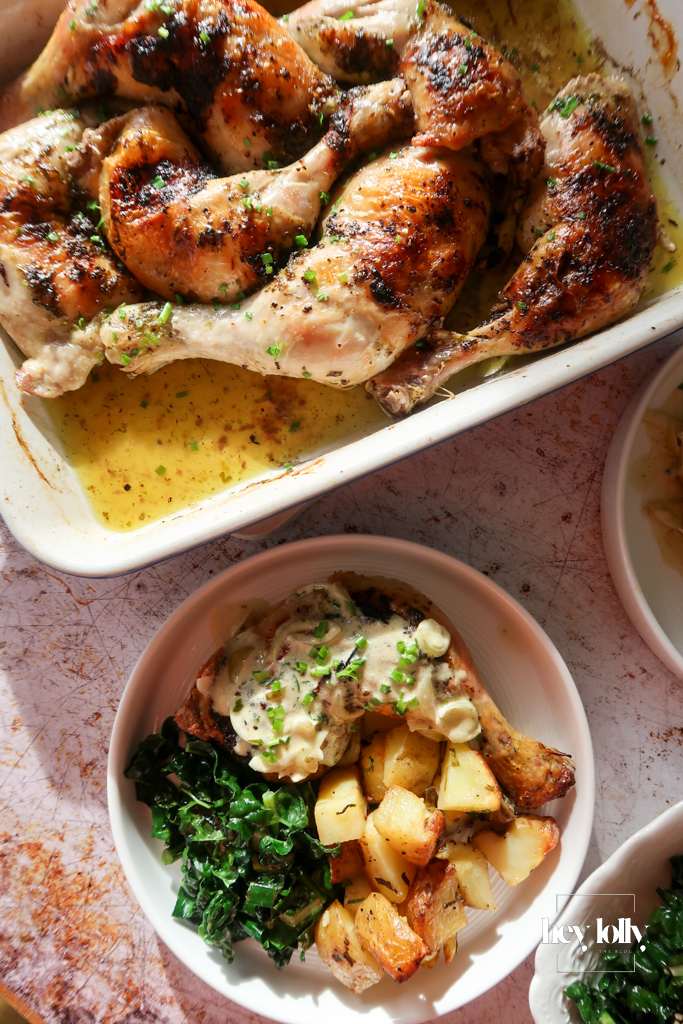 Garlic butter roast chicken with cavolo nero, crispy potatoes, and Dijon cream sauce served on a white plate.