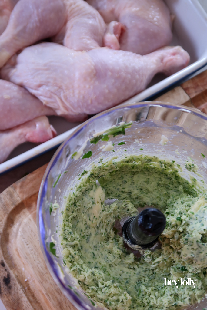 Chicken thighs being rubbed with garlic butter and lemon zest for garlic butter roast chicken recipe.