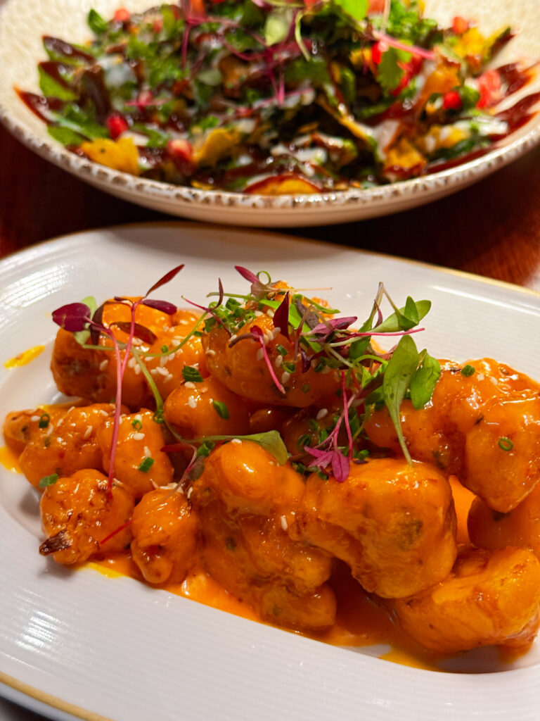 Bang Bang Cauliflower at Passan’s Nottingham — sticky, spicy florets coated in a glossy sauce with fresh herbs.