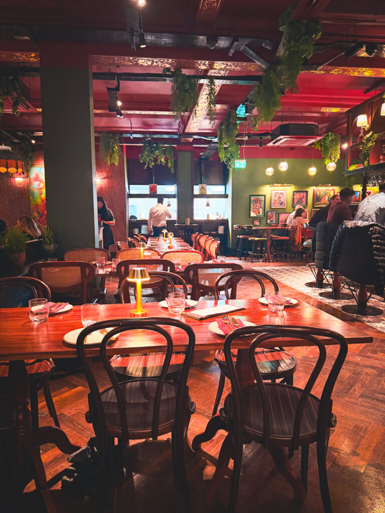 The opulent dining room at Passan’s Nottingham — dark wood, warm lighting, and an open kitchen visible from the floor.