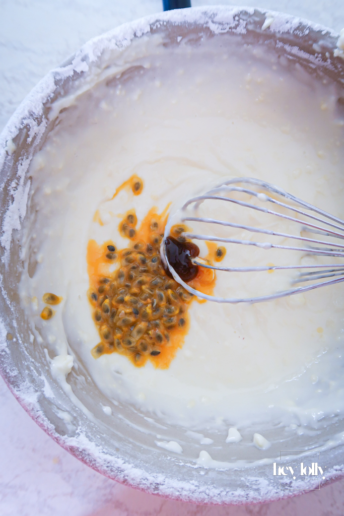Cream cheese frosting being whisked until smooth and creamy for passion fruit yoghurt loaf.