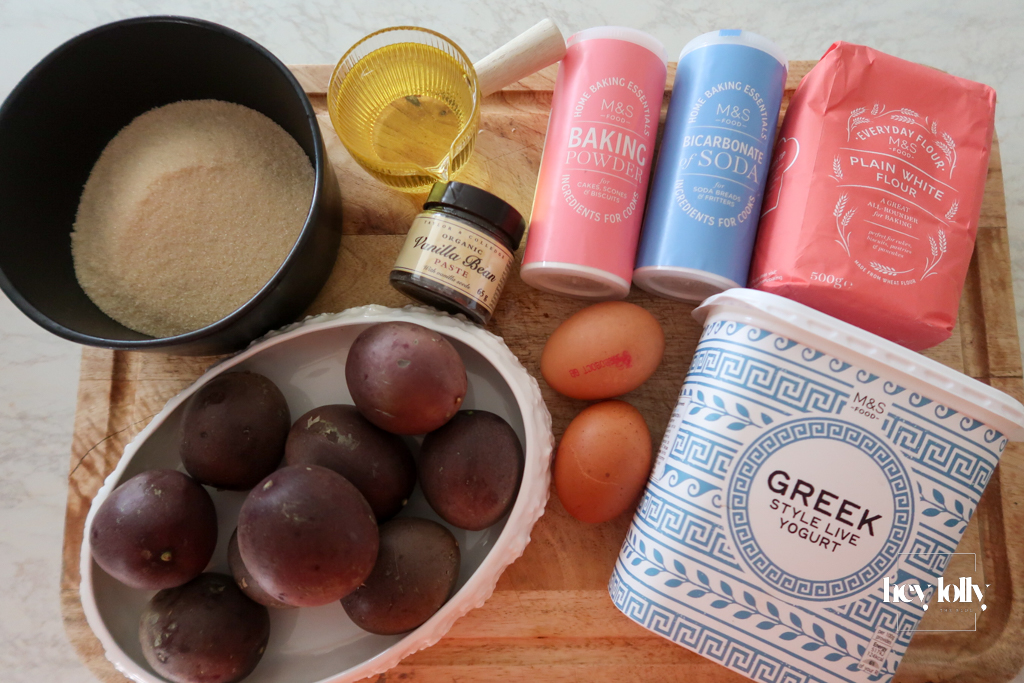 Ingredients for passion fruit yoghurt loaf laid out on kitchen counter — flour, eggs, yoghurt, passion fruits, sugar, and vanilla.