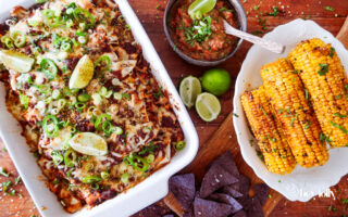 overhead shot of sweetcorn and butter bean enchiladas with salsa and tortilla chips