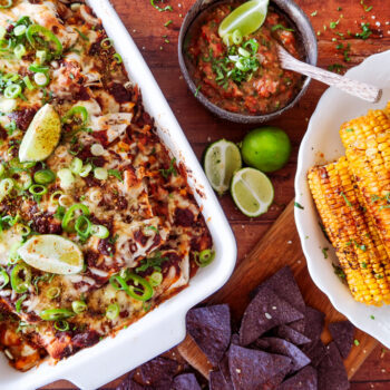 overhead shot of sweetcorn and butter bean enchiladas with salsa and tortilla chips